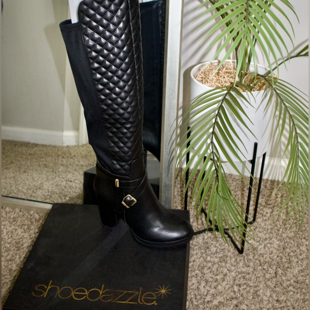 Black knee high boots with gold cross buckle